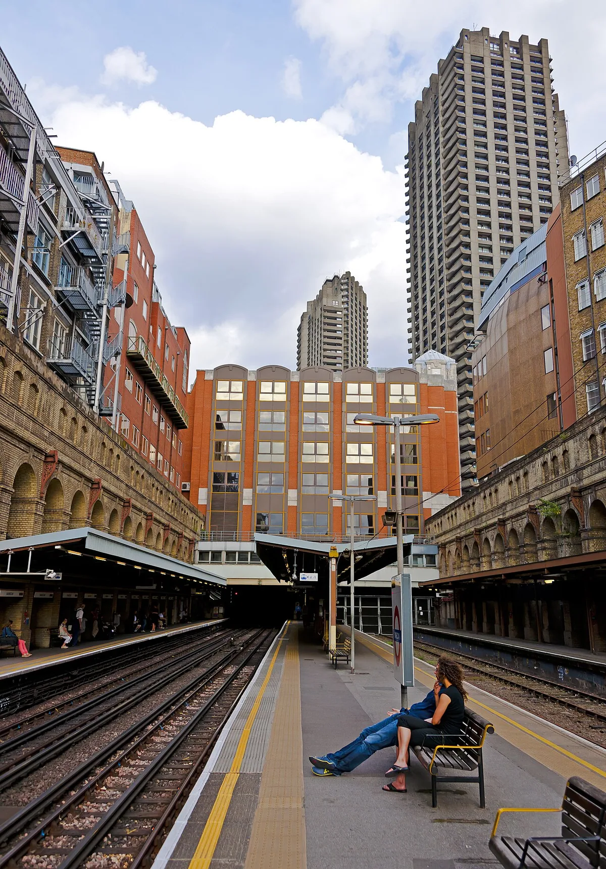 Looking down the platforms at Barbican tube station , London, with towers of the Barbican Estate in the background