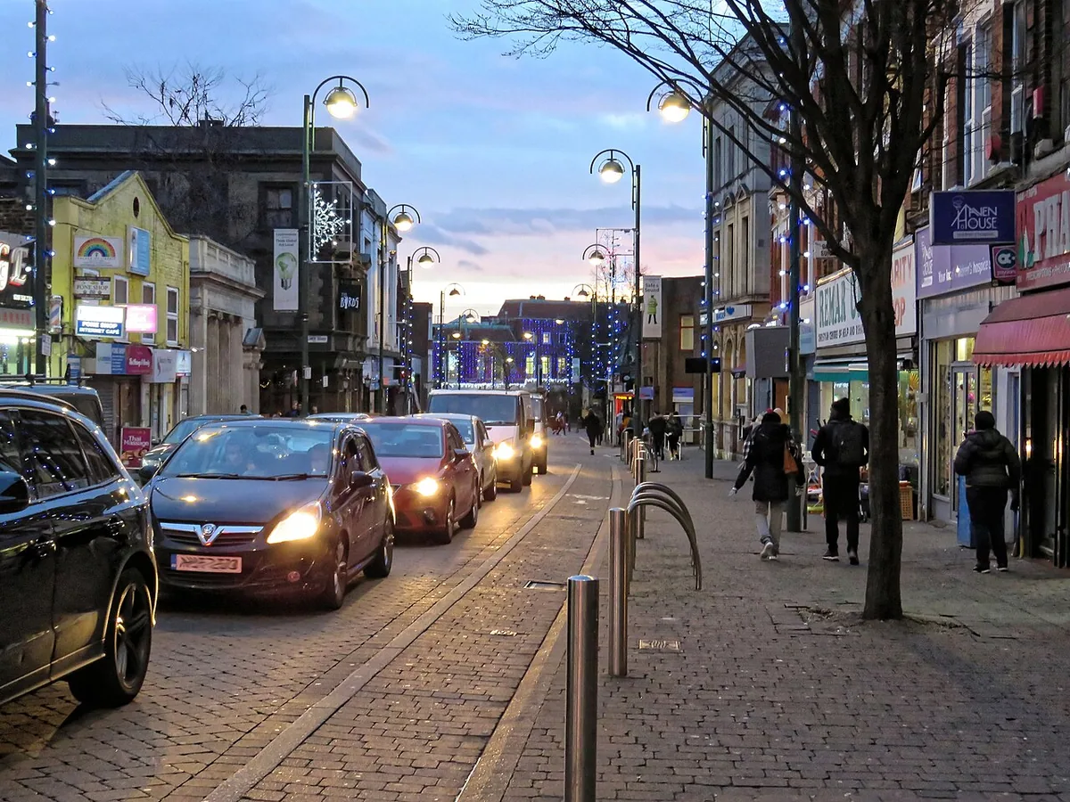Christmas lights and traffic, looking southwest on the one-way section of Leytonstone High Road, East London, England.