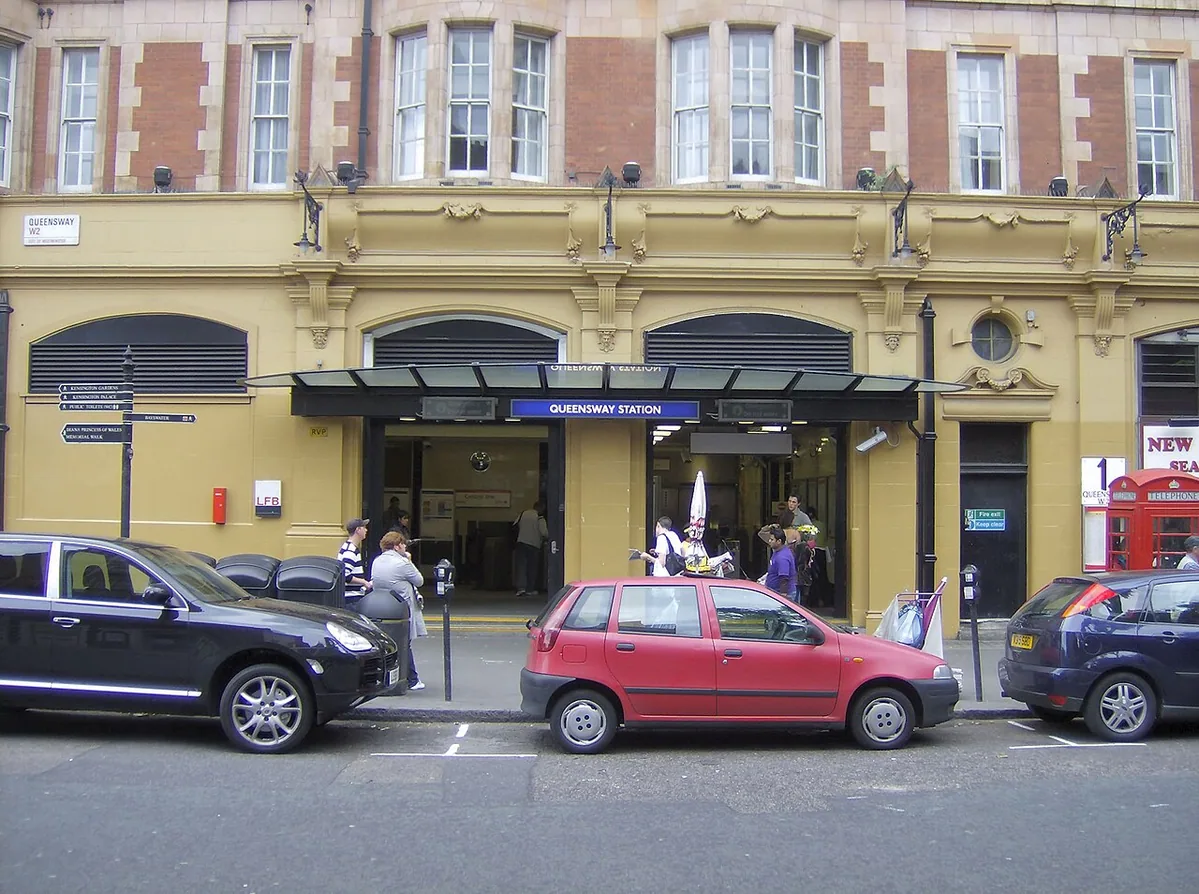 The exterior of Queensway tube station . The building was repainted from red to yellow some time between April 2005 and June 2007.